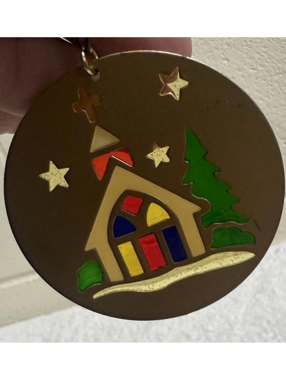 Brass colored Christmas ornaments with colored cut out that shine in the light